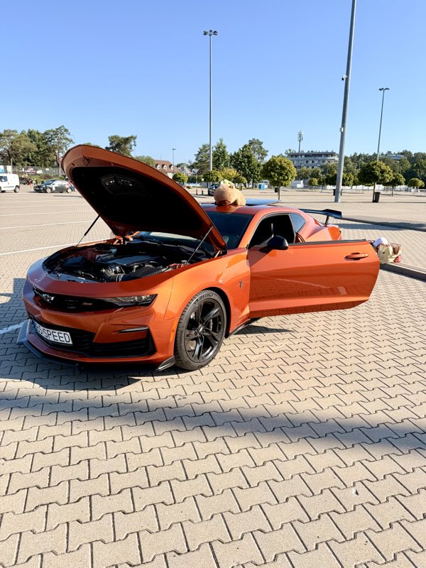 Pomarańczowy Chevrolet Camaro stojący na parkingu